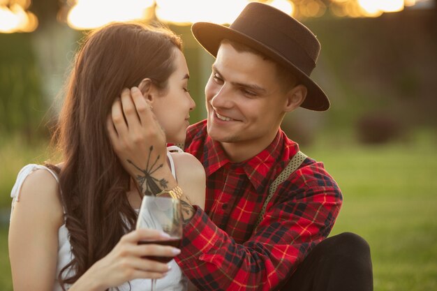 Momenti teneri. Giovani coppie caucasiche che si godono il fine settimana insieme nel parco il giorno d'estate. Sembri adorabile, felice, allegro. Concetto di amore, relazione, benessere, stile di vita. Emozioni sincere.