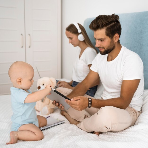 Mon lavora da casa durante la quarantena mentre il papà gioca con il bambino