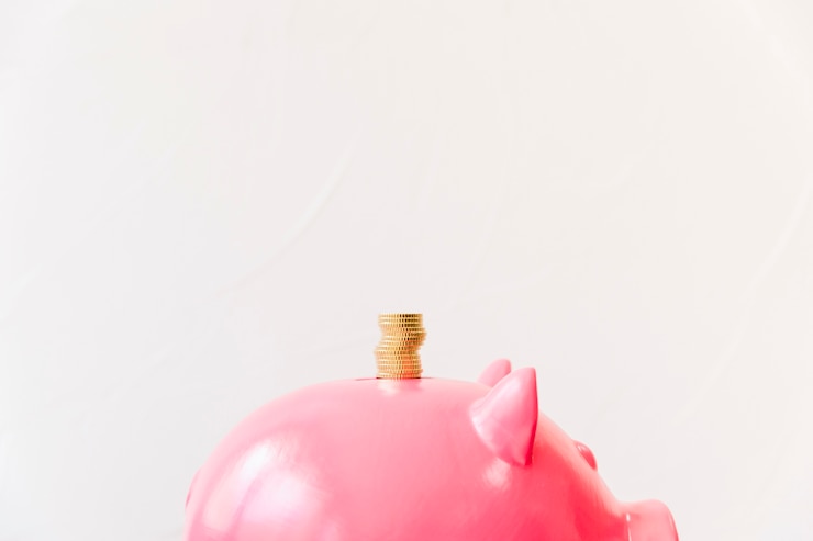Foto gratuito monete dorate impilate sopra lo slot piggybank