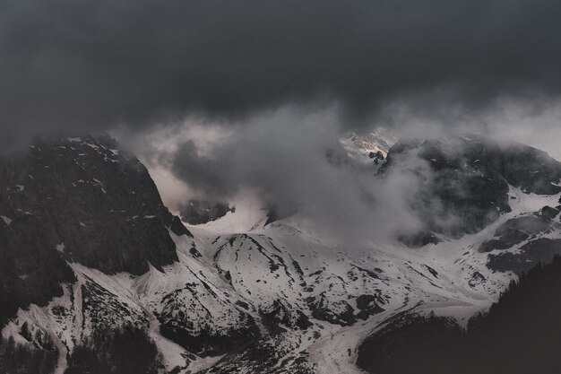 Montagna nera coperta da neve vicino all'acqua