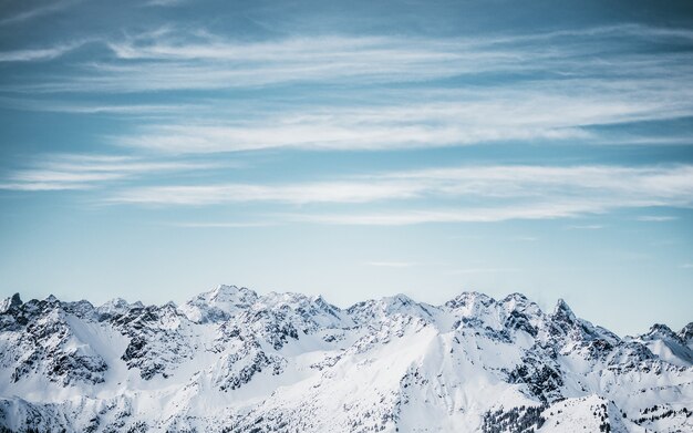 Montagne innevate sotto un cielo nuvoloso blu di giorno