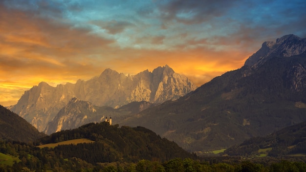 Montagne verdi e marroni sotto il cielo nuvoloso durante il tramonto