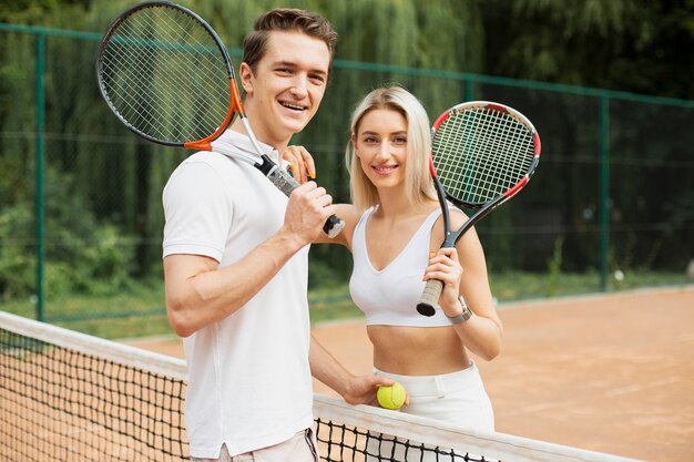 Montare giovani coppie pronte a giocare a tennis