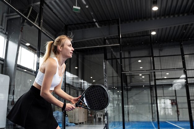 Montare la donna che gioca a paddle tennis vista laterale