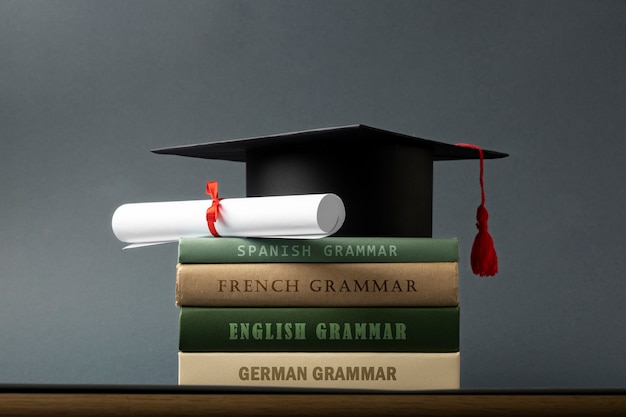 Mortarboard e diploma sui libri di grammatica