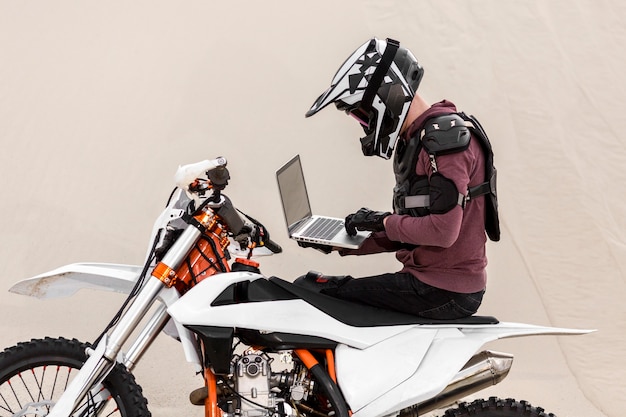 Motociclista che passa in rassegna laptop nel deserto