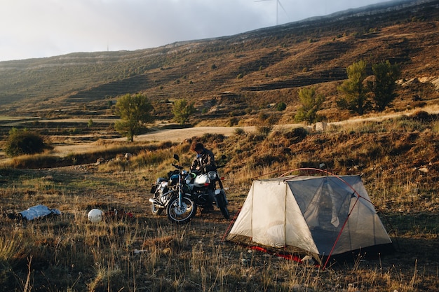 Motociclista d'avventura in campeggio in natura