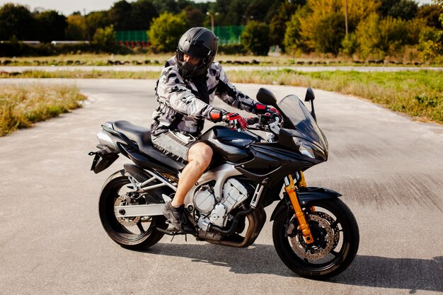 Motociclista sulla moto parcheggiata sulla strada