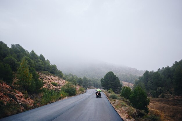 Motociclista sulla strada di campagna vuota