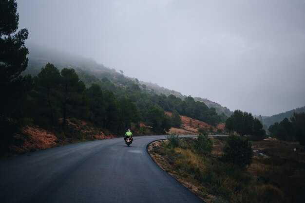 Motociclista sulla strada di campagna vuota