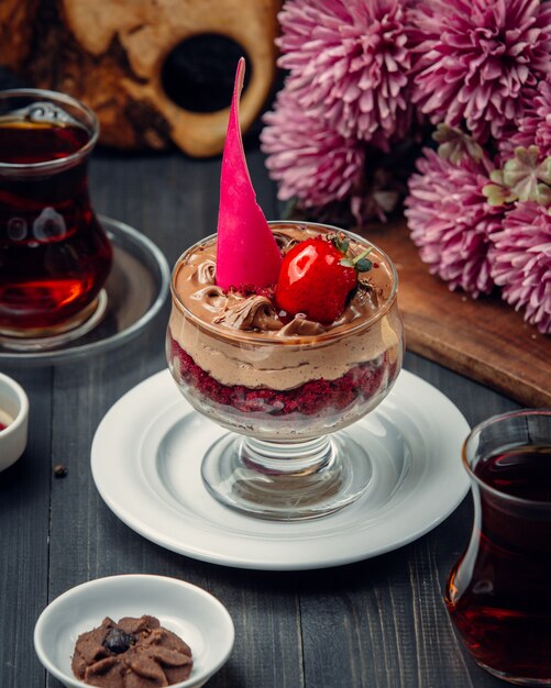 Mousse al cioccolato con fragole all'interno del bicchiere.