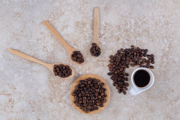 Mucchi di chicchi di caffè e una tazza di caffè