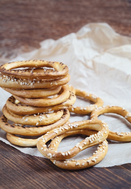 Mucchio di bagel con semi di sesamo su fondo di legno