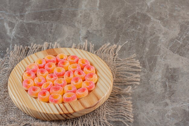 Mucchio di caramelle dolci fresche sul piatto di legno.