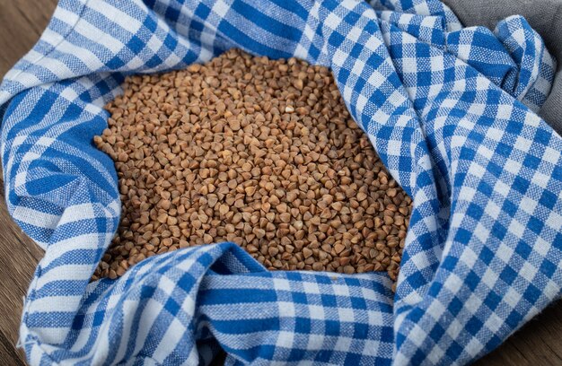 Mucchio di grano saraceno crudo sulla tavola di legno