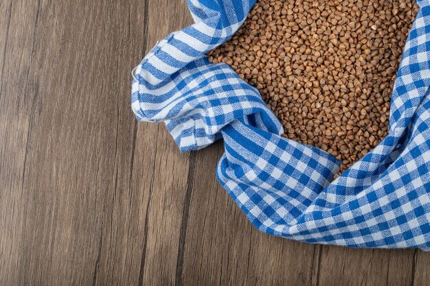 Mucchio di grano saraceno crudo sulla tavola di legno