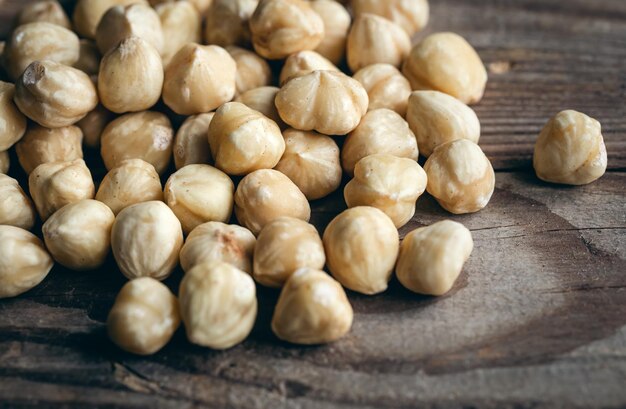 Mucchio di nocciole tostate alzato su uno sfondo di legno