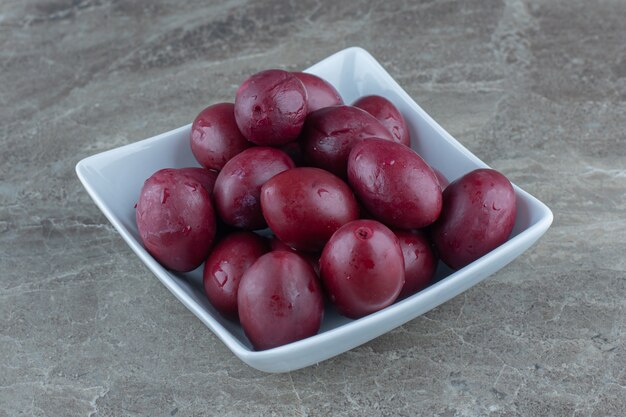 Mucchio di olive in salamoia in ciotola di ceramica bianca