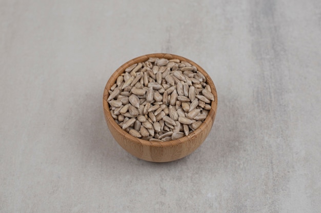 Mucchio di semi di girasole in ciotola di legno.
