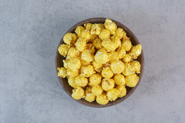 Mucchio ricoperto di caramelle gialle di popcorn su marmo.