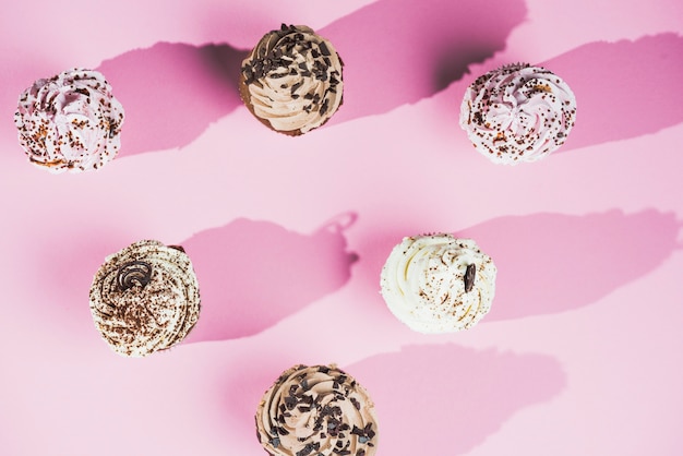 Muffin al cioccolato ripieni di crema dolce su sfondo rosa