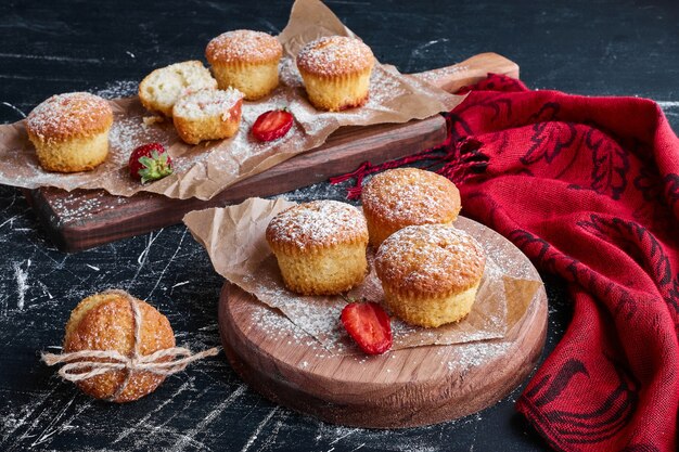 Muffin con frutti di bosco su tavole di legno.