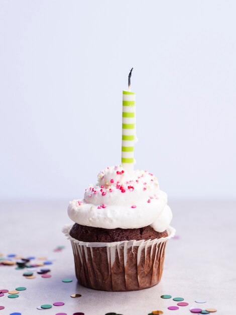 Muffin del primo piano piccolo con la candela verde