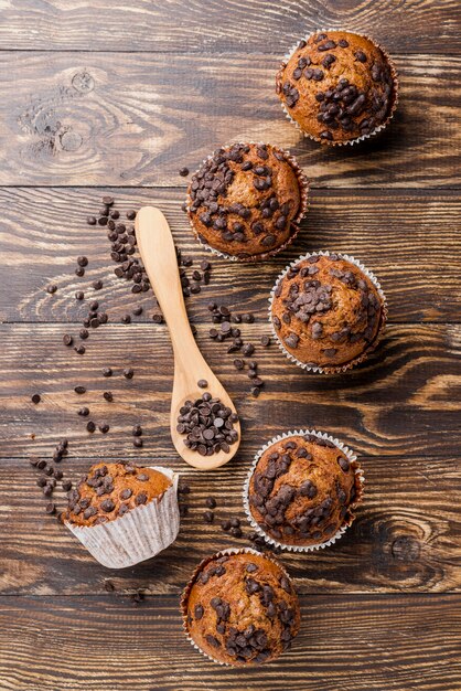 Muffin deliziosi di vista superiore su fondo di legno