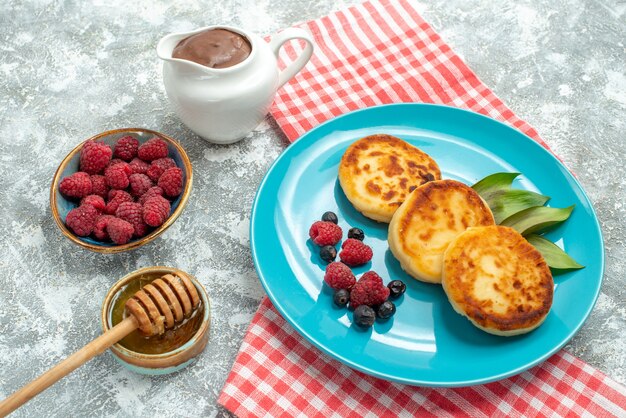 Muffin deliziosi vista frontale con frutti di bosco sul tavolo luminoso