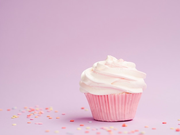 Muffin di compleanno semplice su sfondo rosa