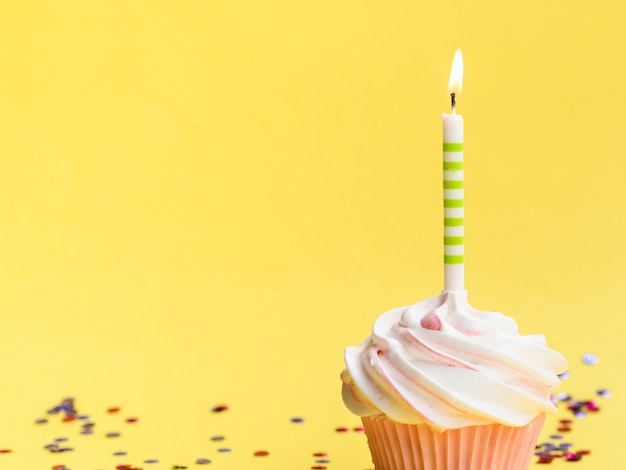 Muffin e candela semplici di compleanno del primo piano