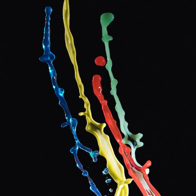 Multi vernice colorata che spruzza su sfondo scuro