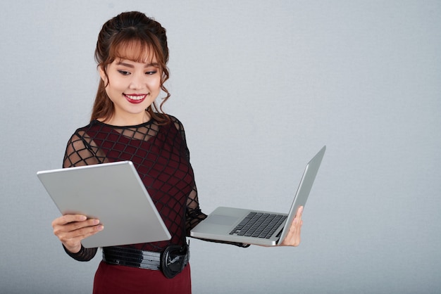 Multitasking della donna di affari di Beauitiful sul PC del computer portatile e della compressa