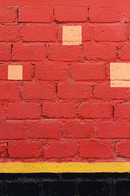 Muro di mattoni rossi con macchie gialle