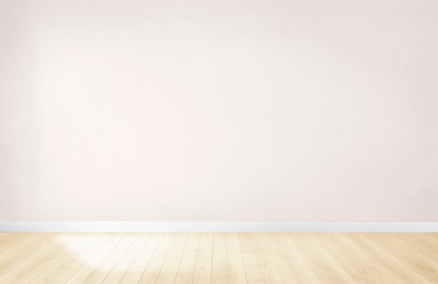 Muro rosa chiaro in una stanza vuota con un pavimento in legno