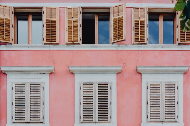 Muro rosa e finestre bianche