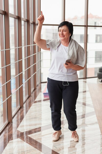 Musica d'ascolto della donna senior alla palestra