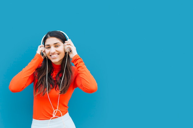 Musica d&#39;ascolto della giovane donna graziosa con la cuffia