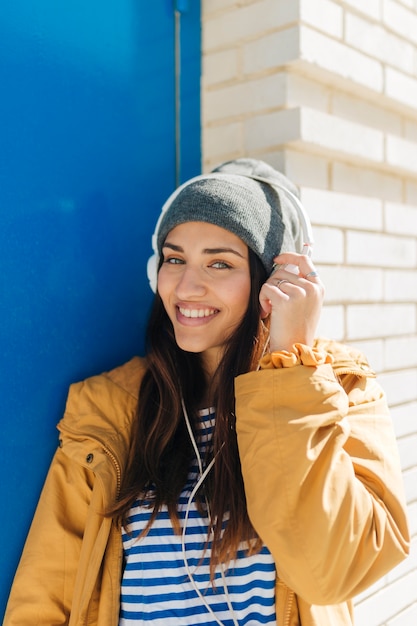 musica d&#39;ascolto sorridente della donna che esamina macchina fotografica