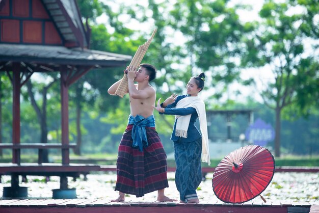 Musica thailandese, donne danzanti e uomo in costume in stile nazionale: danza thailandese