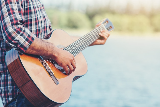 musicista adulto bello suonare la chitarra acustica