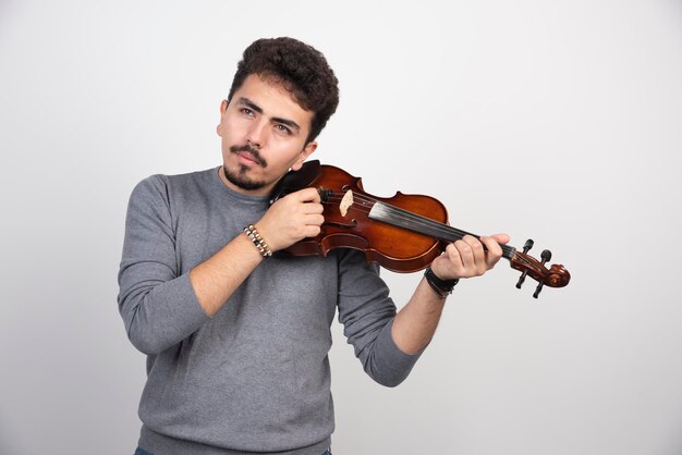 Musicista che controlla e aggiusta la melodia del suo violino.