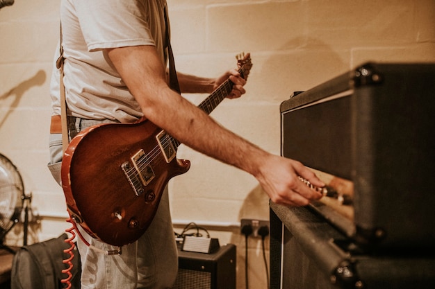 Musicista che imposta amplificatore per chitarra, foto della sessione di registrazione in studio