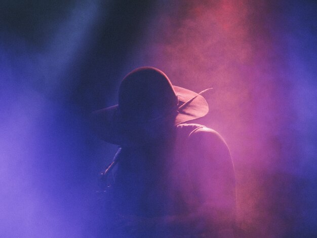 Musicista che suona il sassofono in un concerto in un club su un palco fumoso scuro