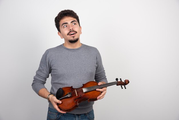 Musicista che tiene il violino e pensa al prossimo pezzo da suonare.