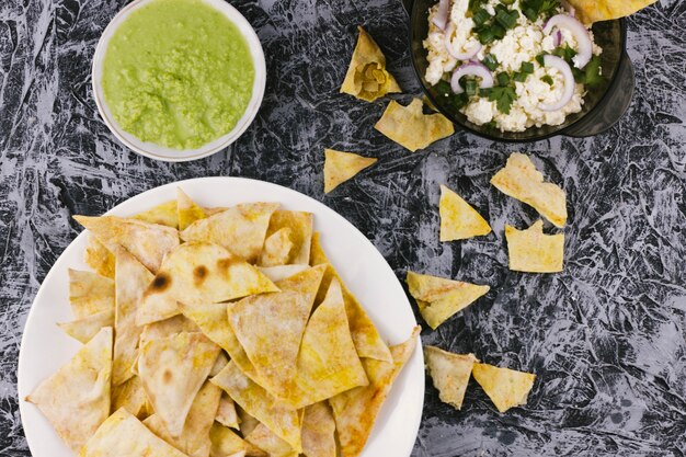 Nachos e salsa di guacamole su sfondo di marmo