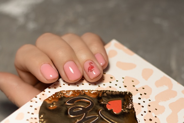 Nail design rosa. Mano femminile con manicure rosa.