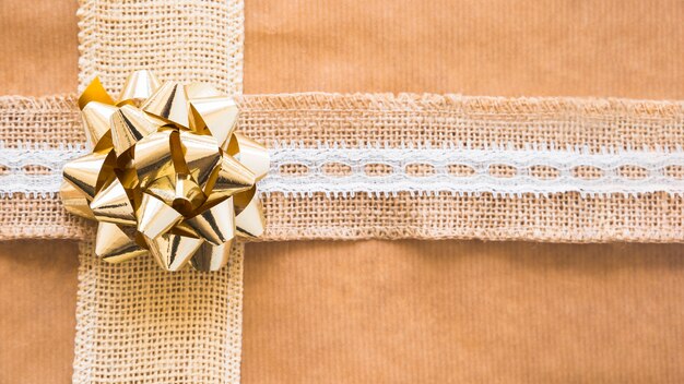 Nastro decorativo per tessitura e fiocco dorato su carta regalo