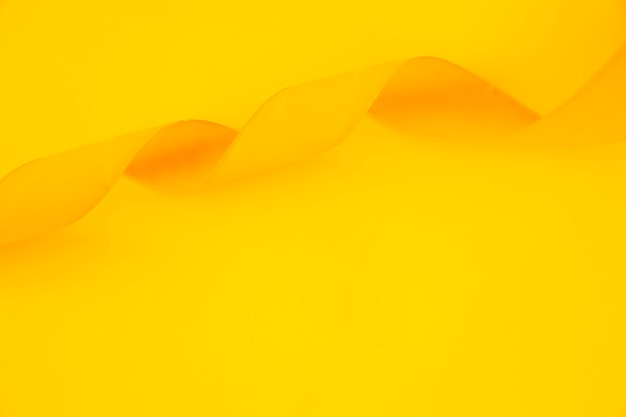 Nastro di raso arricciato su sfondo giallo