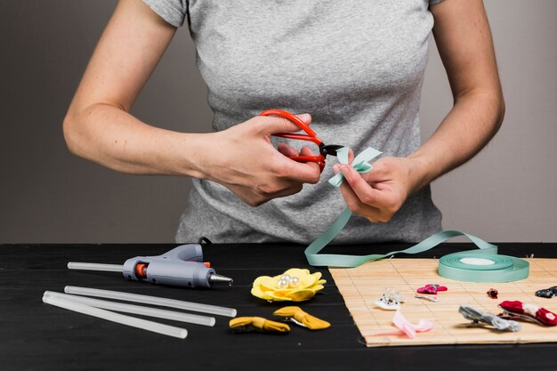 Nastro di taglio donna con forbice durante la realizzazione di vari fermagli per capelli